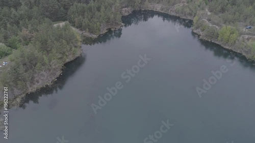 Aerial view of a beautiful lake at the site of a former granite quarry near the town of Korostyshev, Ukraine. 4k video. Beautiful landscapes of wild nature with a lake with high banks of stone photo
