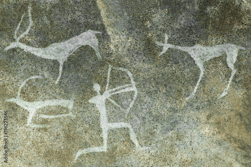 An image of a hunt on a cave wall made by an ancient man. ancient world history. archeology