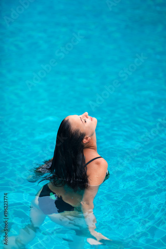 young brunette woman sunbathe swimming pool