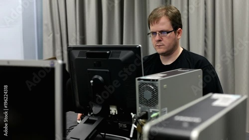 Male working late at a computer station in a lab on homework.
 photo
