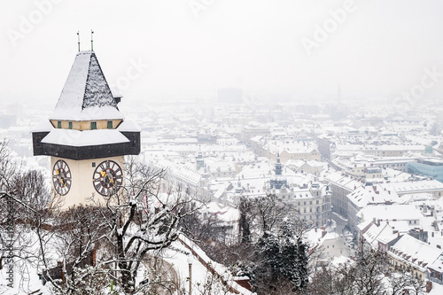 Fotografie Snowy Uhrturm clocktower landmark on hill Schlossberg and city Graz