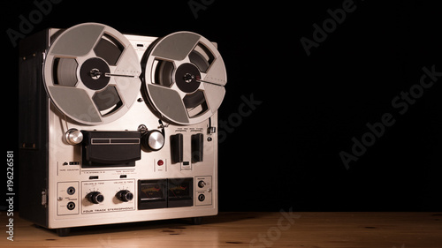 Reel to Reel taperecorder playing music isolated on black background and space for copy