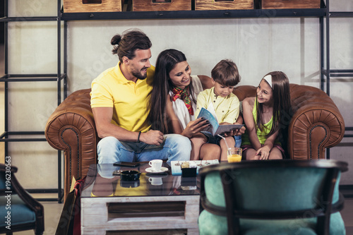 Family with two children having great time in a cafe after shopping