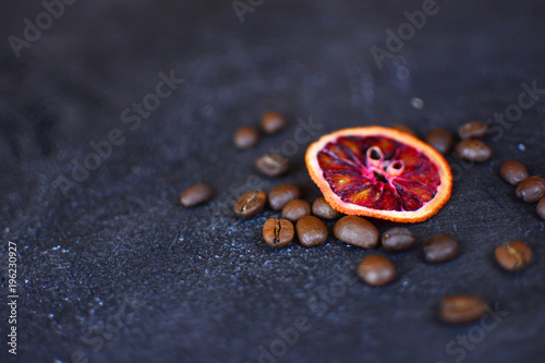Beautiful and tasty background for design. Dried red orange slices with a coffee beans on a stone background. Cuisine wallpaper.