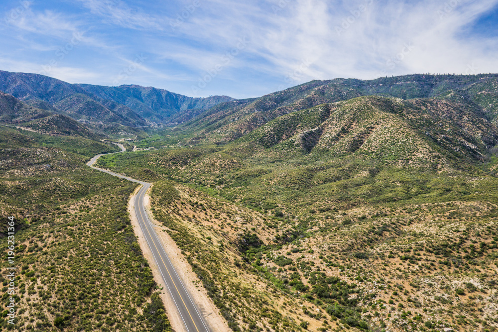 Asphalt road winds through the hills and canyons of southern California's Mojave Desert.