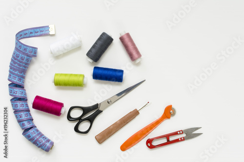 Tailor's work desk. Pattern of sewing accessories and tools on white background top view copyspace