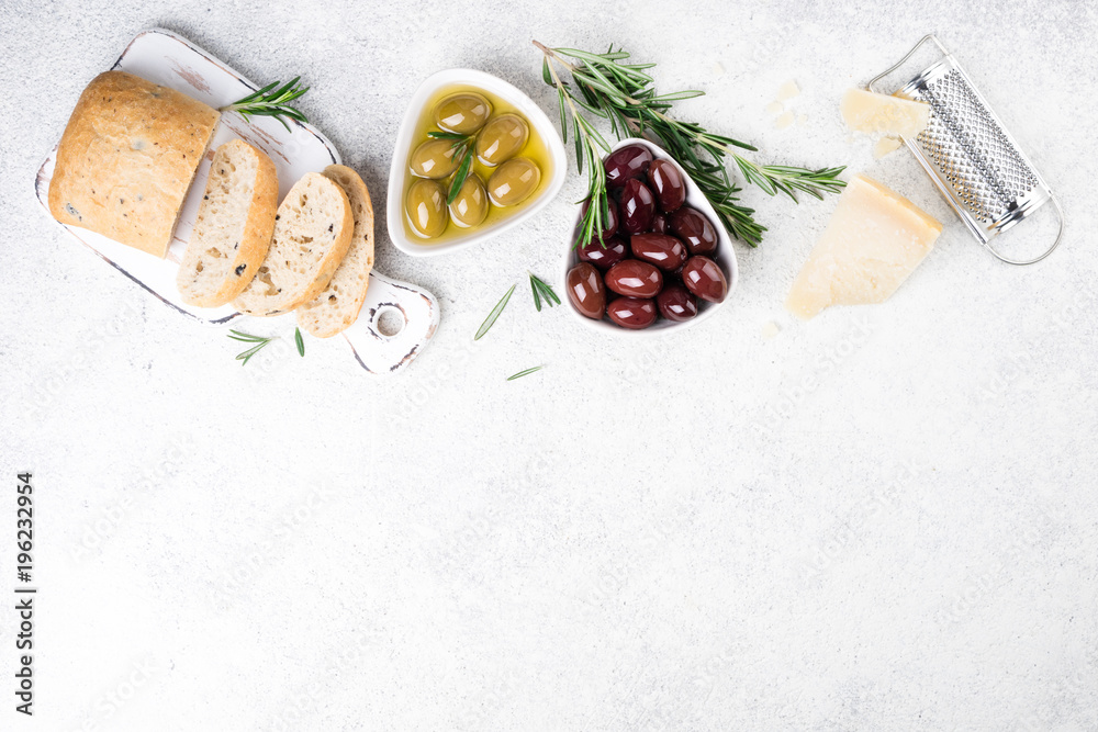 Fototapeta Ciabatta chleb, oliwki, ser, olej, rosemary zioło na białym tle. Przekąski śródziemnomorskie lub włoskie. Widok z góry, kopia przestrzeń