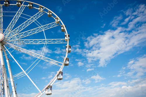 Horizontal View of a White Ferris Wheel on Partially Cloudy Sky Background. Copy Space. Bari, South of Italy