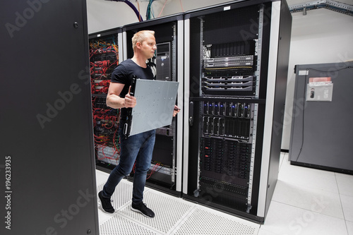 Computer Engineer Carrying Blade Server While Walking In Datacen photo