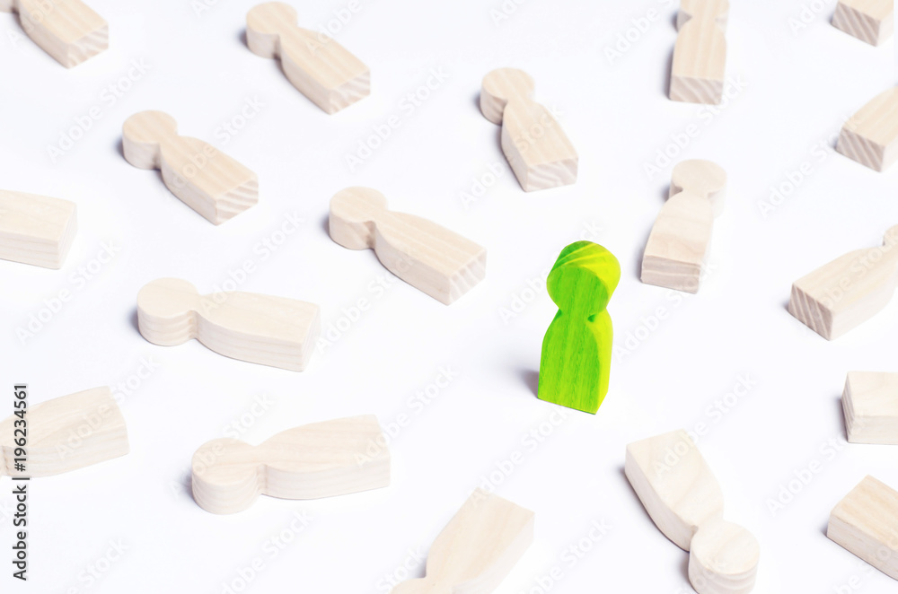 A person is in the spotlight. A green wooden figure of a man. Concept business idea. Best in the business. People lie around. Victory, progress, innovation. A person is in the spotlight. A green wooden figure of a man. Concept business idea. Best in the business. People lie around. Victory, progress, innovation.