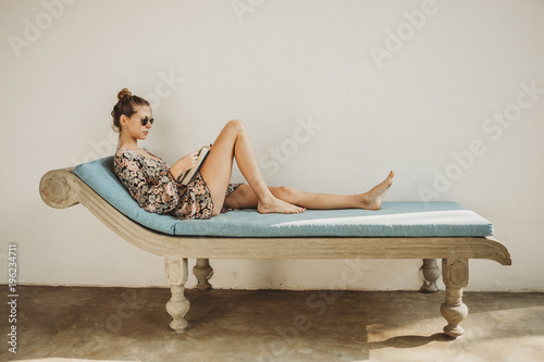 Young woman relaxing on chaise longue photo
