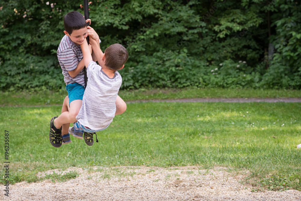 Children playing in park on zip line swing Children playing in park on zip line swing