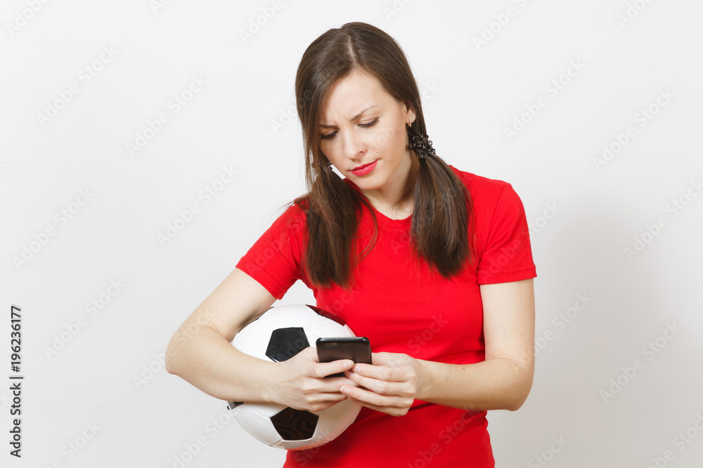 European young angry screaming woman, football fan or player in yellow uniform send sms on mobile phone, hold soccer ball isolated on white background. Sport, play football, healthy lifestyle concept. European young angry screaming woman, football fan or player in yellow uniform send sms on mobile phone, hold soccer ball isolated on white background. Sport, play football, healthy lifestyle concept.