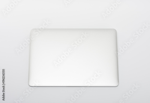 Closed modern, new laptop on white background, top view.