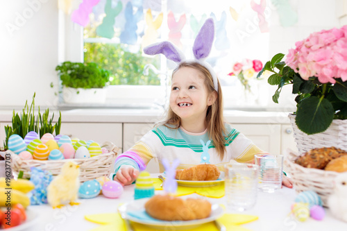 Kids at Easter breakfast. Eggs basket, bunny ears.