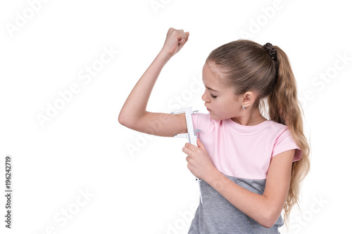 Girl measures the muscles with a caliper