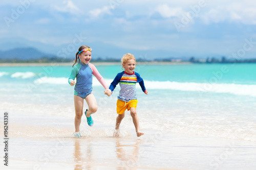 Kids on tropical beach. Children playing at sea.
