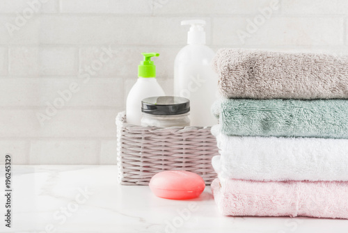 Spa relax and bath concept, sea salt, soap, with cosmetics and towels in bathroom white background, copy space top view