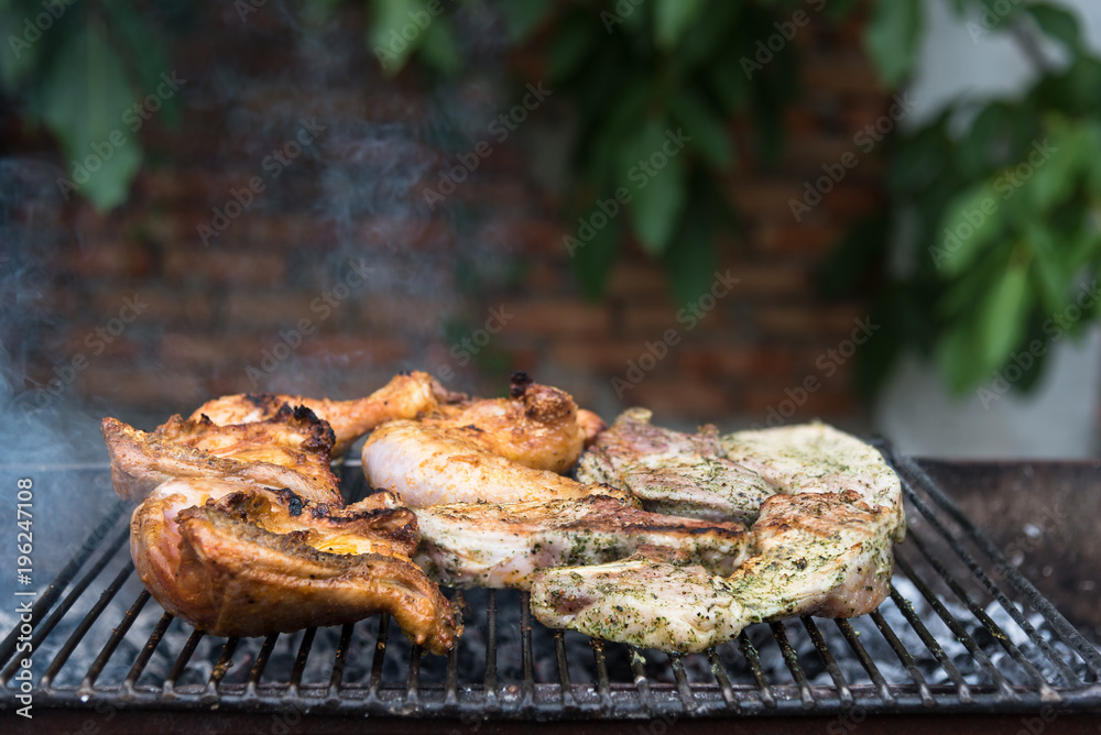 Steaks and chicken thighs on the grill, rest with friends in the open air Steaks and chicken thighs on the grill, rest with friends in the open air