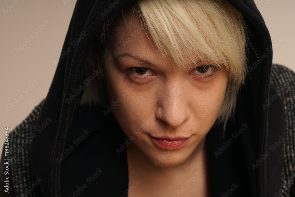 Young blonde girl portrait with black hoodie. Looking tough.