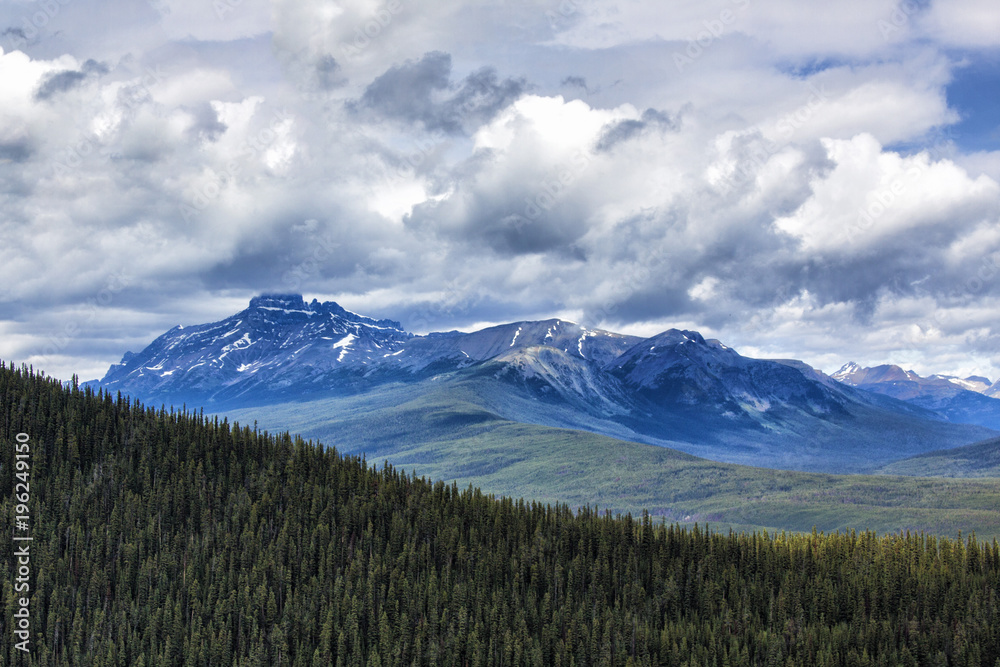 Forest, mountains and sky with dramatic clouds