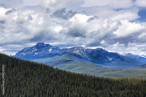Forest, mountains and sky with dramatic clouds
