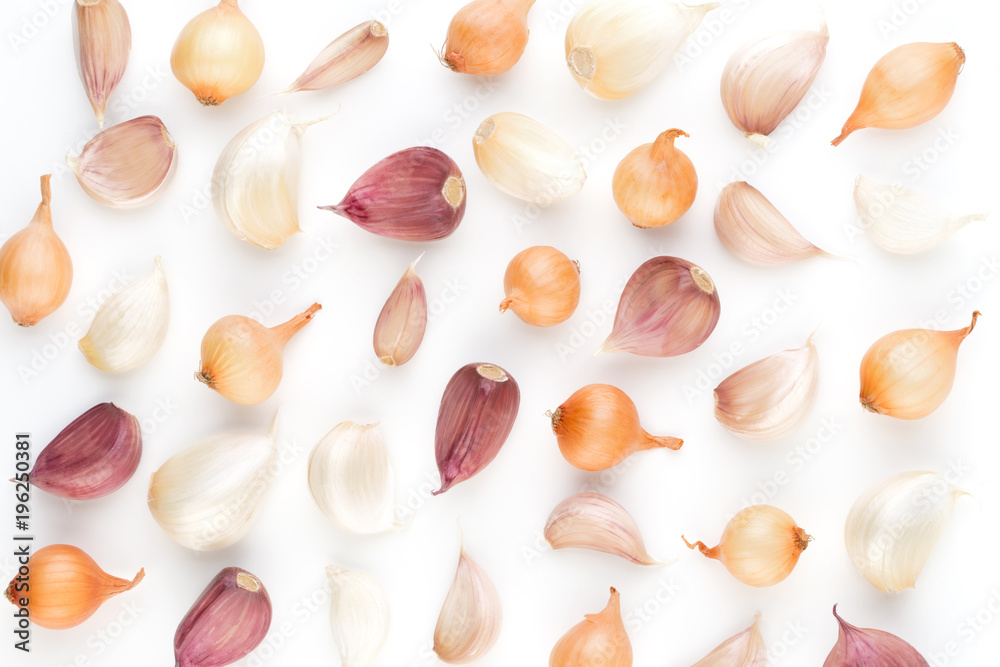 Onion and garlic isolated on white background, top view. Wallpaper abstract composition of vegetables.