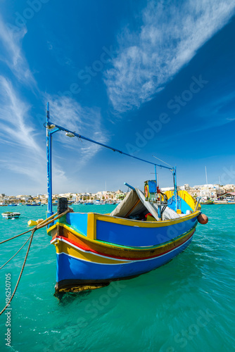 Beautiful painted fishing boat on turquoise water in Marsaxlokk,Malta