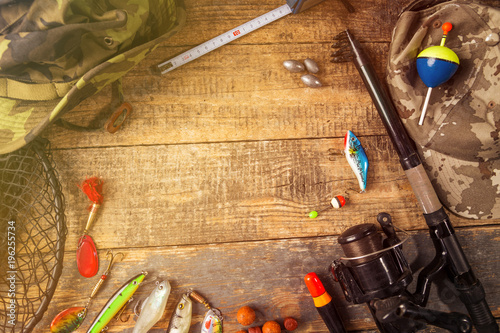 Fishing equipment on wooden background.