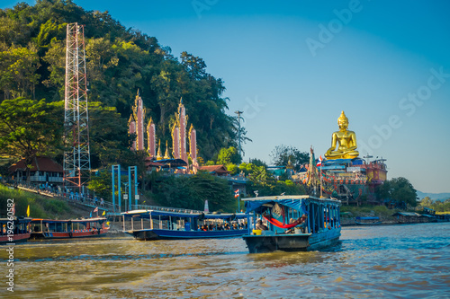 Outdoor view of a group of tourists in a tourist boat visiting the golden budha located at golden triangle Laos photo