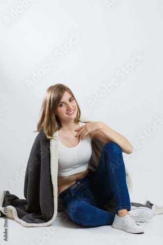 brunette girl sits on a plaid, on a white background