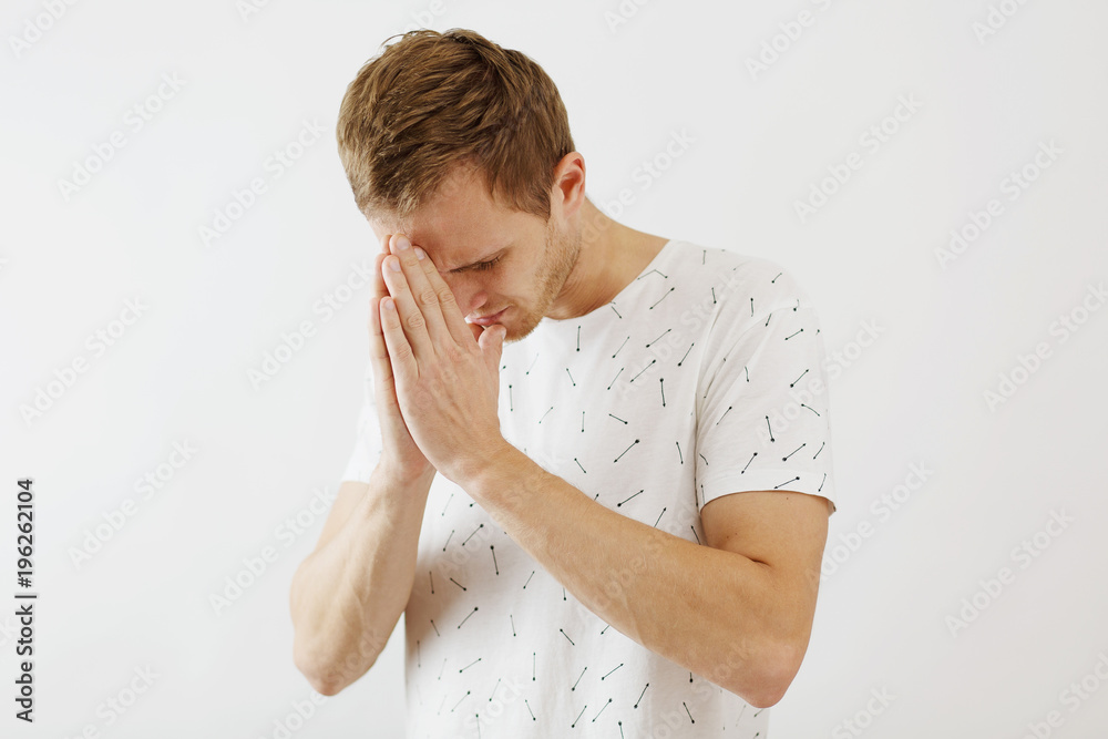man praying, holding hands together near forehead, on white background man praying, holding hands together near forehead, on white background