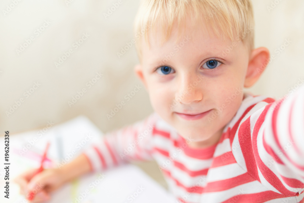 Cute child draws a house and family on paper Cute child draws a house and family on paper