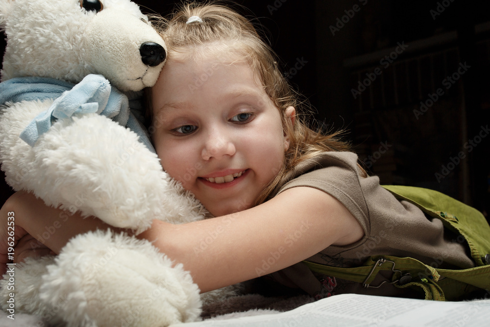 Beautiful little girl read book with her favorite bear Beautiful little girl read book with her favorite bear