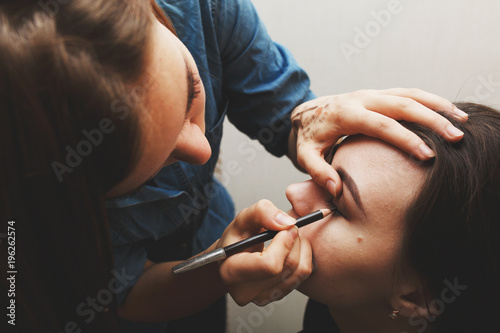 Make-up artist does make-up for brunette