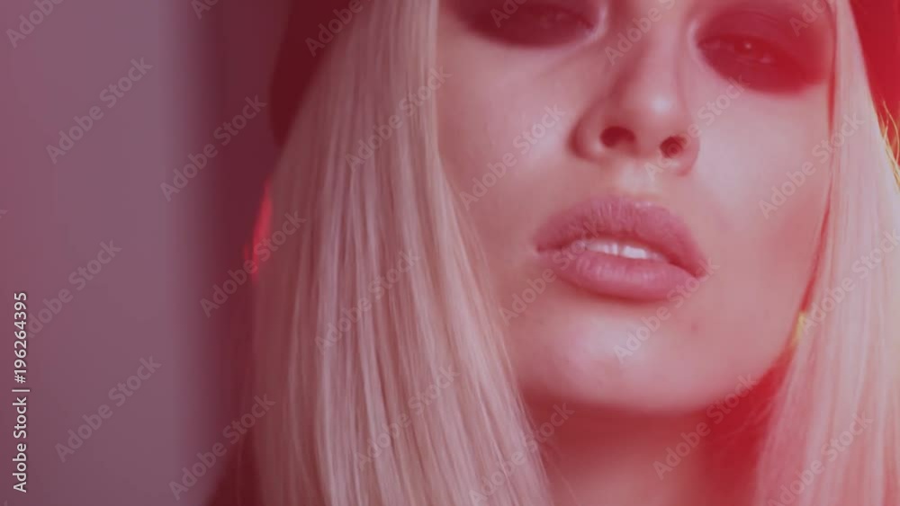 beautiful blonde girl with black glasses posing in studio with red light beautiful blonde girl with black glasses posing in studio with red light