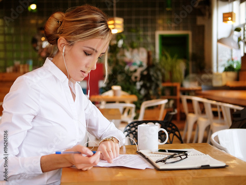  Close-up of young beautiful business woman writing in notebook 