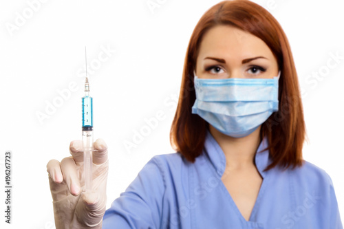 Healthcare and medicine. Woman doctor  a nurse with a syringe in her hands  uses  picks up a syringe isolated on white background