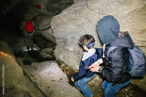 children explore underground caves, an underground karst complex of Cunardo, Lombardy, Italy