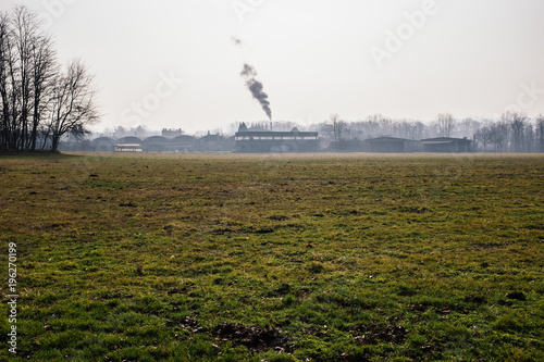 chimney of a factory expels vapors in the countryside