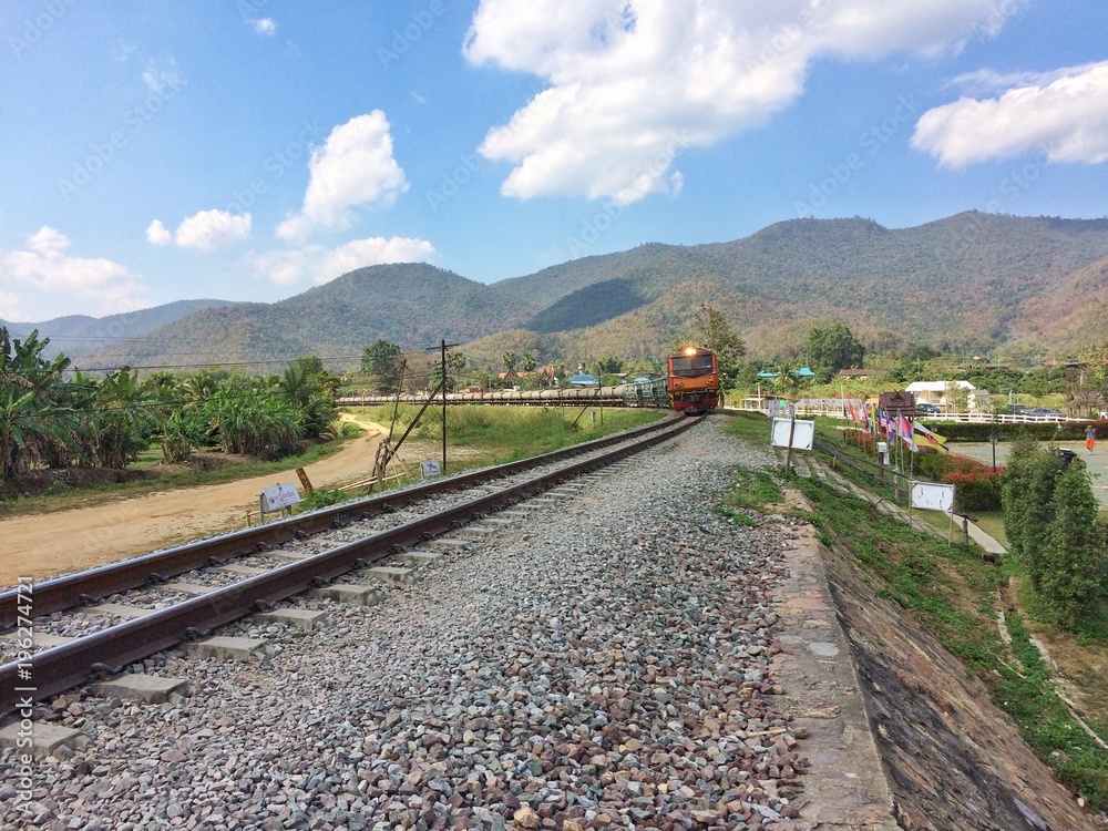 Train running on metal railway with the moutian landscape countryside at Lampang province Northern Thailand.