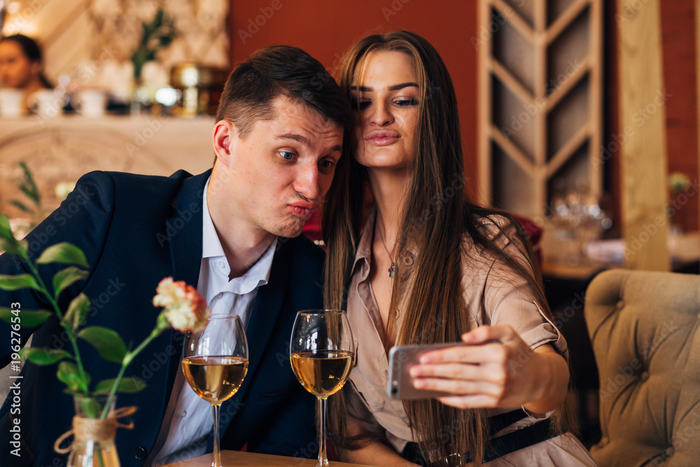 Happy young couple taking selfie with smart phone at cafe Happy young couple taking selfie with smart phone at cafe