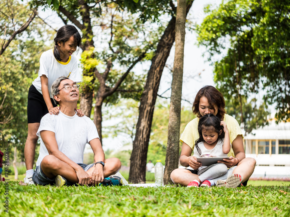 Activities in the family, Grandfather, mother and daughter relaxing in the park after exercise Activities in the family, Grandfather, mother and daughter relaxing in the park after exercise