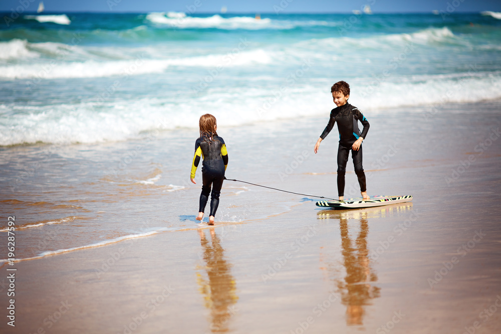 children playing with a bodyboard Stock Photo | Adobe Stock