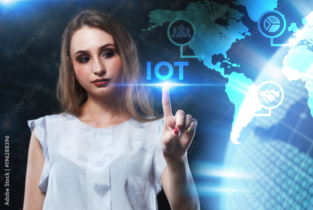 The concept of business, technology, the Internet and the network. A young entrepreneur working on a virtual screen of the future and sees the inscription: IOT The concept of business, technology, the Internet and the network. A young entrepreneur working on a virtual screen of the future and sees the inscription: IOT