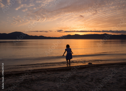 水辺で遊ぶ子ども 夕日