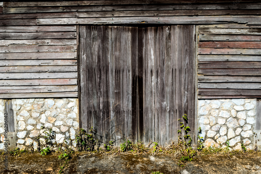 Background of the old wooden window with old stone and wooden wall in Thai house styles Background of the old wooden window with old stone and wooden wall in Thai house styles