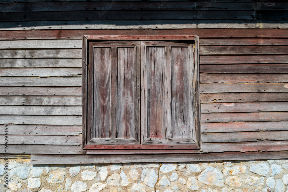 Background of the old wooden window with old stone and wooden wall in Thai house styles Background of the old wooden window with old stone and wooden wall in Thai house styles