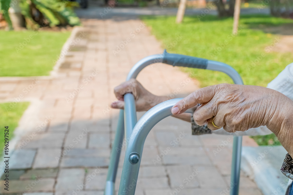 Elderly woman using walker in backyard