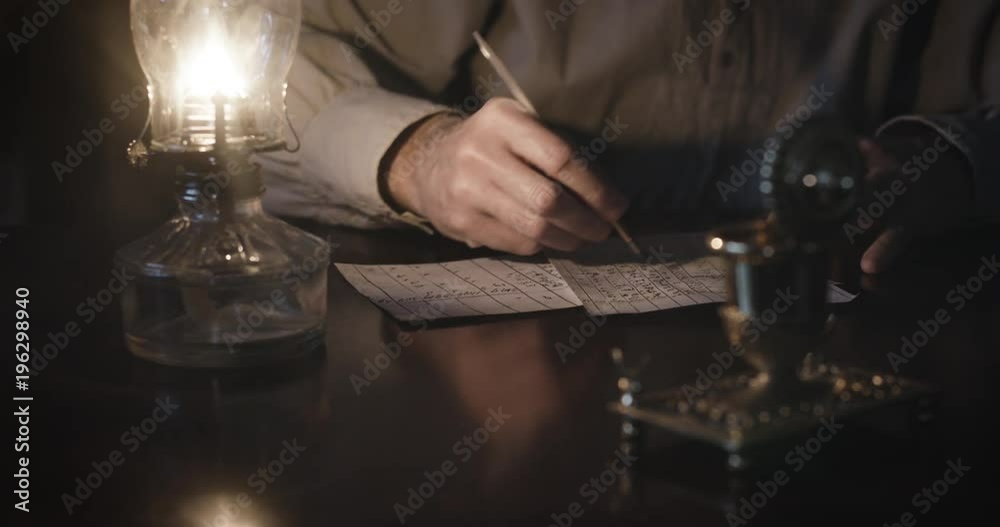 Scene tracks the action of the hand of a Caucasian male using a period appropriated vintage 1800s dip pen to write with.